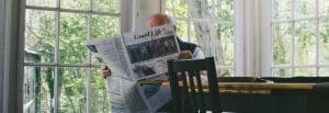 older man reading newspaper